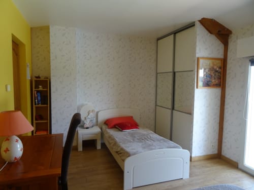 Chambre lumineuse au gîte CafecouetBreizh à Guipry-Messac avec lit simple, armoire, bureau et mur jaune