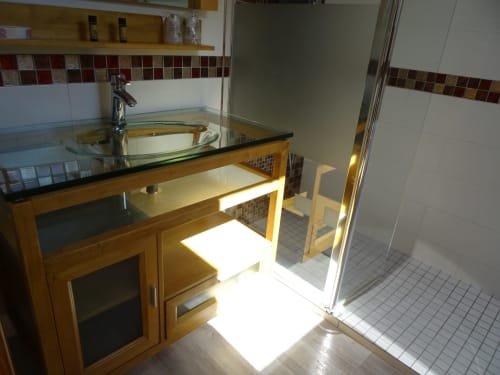 Salle de bains moderne de la chambre La Pepsie au Gîte CafecouetBreizh, Guipry-Messac, avec lavabo en verre, meuble vasque en bois et vue sur le jardin