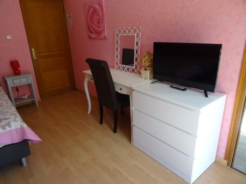 La chambre La Pepsie du gîte CafecouetBreizh à Guipry-Messac avec murs roses, commode blanche, télévision écran plat et bureau