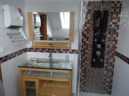 Salle de bain moderne à la chambre La Pepsie du gîte CafecouetBreizh, Guipry-Messac : douche vitrée, meuble vasque en bois et carrelage en mosaïque rouge