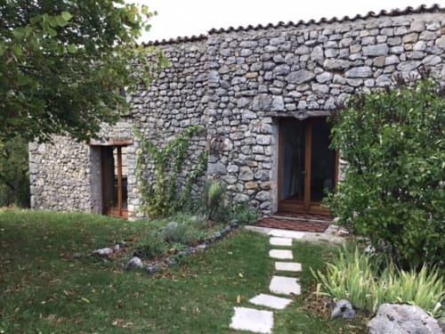 Façade de cottage en pierre à Entre Terre Et Ciel, gîte français à Rémuzat avec jardins luxuriants et entrée accueillante