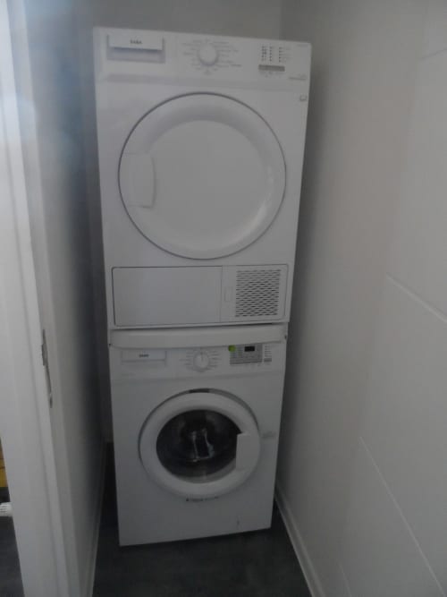 Lave-linge et sèche-linge empilés dans la buanderie du gîte CafecouetBreizh à Guipry-Messac, France