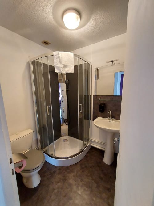 Salle de bain moderne au Gîte Le Comtois en Saône, France avec douche, toilettes et lavabo sur piédestal