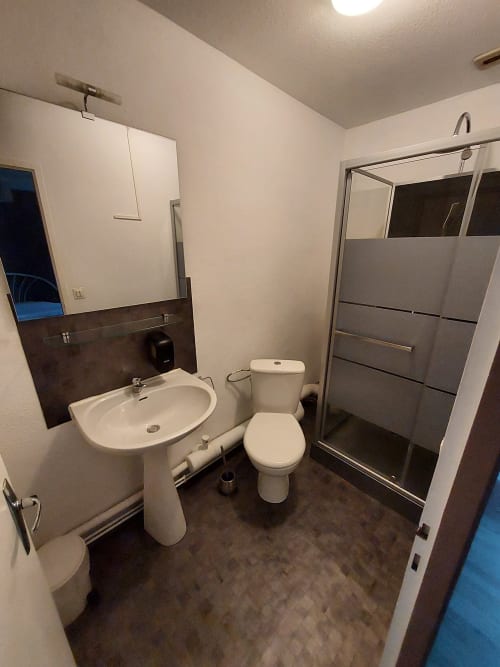 Salle de bain moderne au Gîte Le Comtois en Saône, avec lavabo sur pied, toilettes et cabine de douche