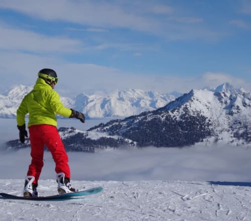 Skieur en veste néon surplombant les montagnes enneigées près de La Tzoumaz, Suisse