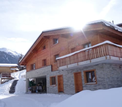 La Tzoum'hostel BnB à La Tzoumaz, Suisse : chalet moderne en bois avec soubassement en pierre dans un cadre alpin enneigé