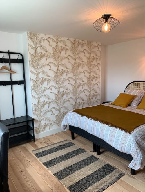 Chambre moderne aux Remparts de Joussaume Latour BnB à Château-Thierry avec papier peint tropical et literie ocre