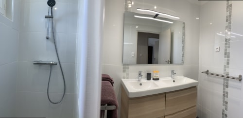 Modern bathroom at Gites Mas D'en Ratéro cottage with dual sink vanity, large mirror, and walk-in shower in Thuir, France
