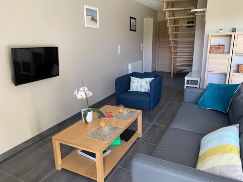 Modern living room in Cottage L'Olivier at Gites Mas D'en Ratéro, Thuir, with blue armchair, gray sofa, wooden coffee table,