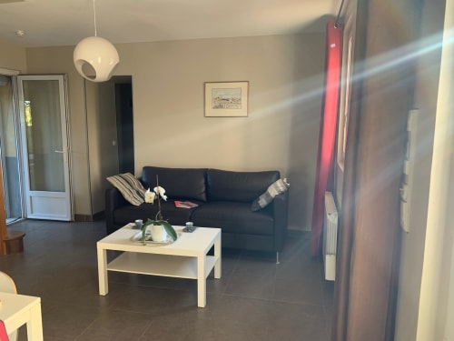 Modern cottage living room with black sofa, white coffee table, pendant light at Mas D'en Ratéro in Thuir