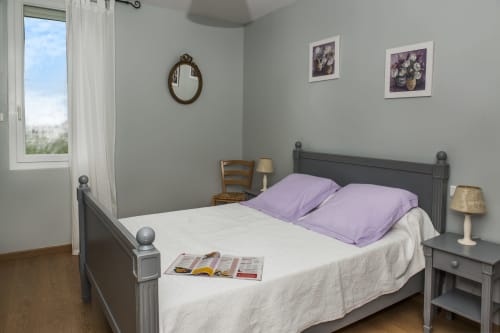 Bright bedroom in Cottage Força Réal at Gites Mas D'en Ratéro, Thuir with double bed, purple pillows, mountain views, and