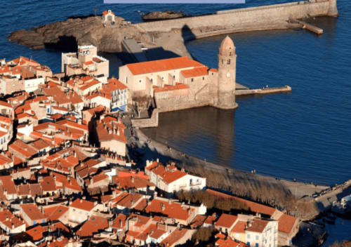 Petite ville côtière méditerranéenne avec toits rouges, clocher d'église et port - Thuir, France