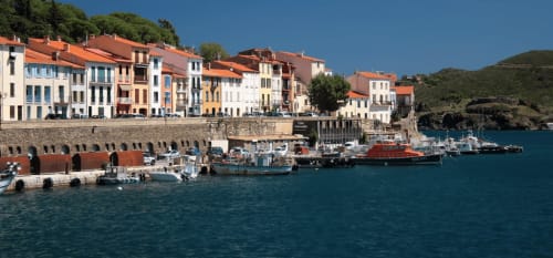 Village côtier méditerranéen coloré avec toits en terre cuite, bateaux et eau turquoise du port près de Thuir, France