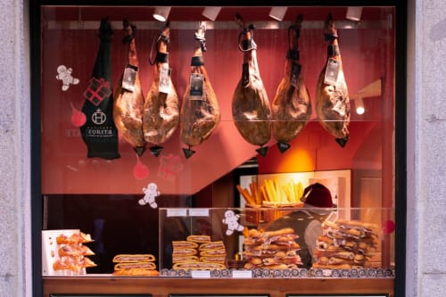 Vitrine de charcuterie à Thuir avec viandes séchées suspendues, pâtisseries et produits de charcuterie française traditionnelle