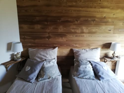 Twin beds with wooden headboard in La Maison De L'Épine mountain cottage, Aime la Plagne, with bedside lamps and modern