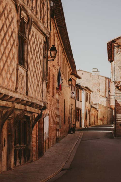 Charming medieval brick street in Montaut, France with traditional stone buildings and historic architecture