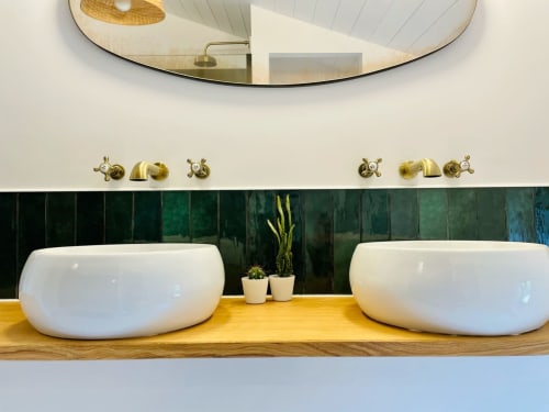 Luxueuse vasque double dans la suite Bulle de la Maison Monsieur Léger, avec dosseret en carreaux verts et accessoires en laiton