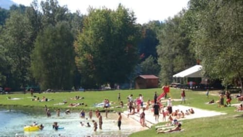 Guests enjoying outdoor recreation at La Maison De L'Épine, a Aime la Plagne B&B, with lake swimming, sandy beach, and alpine