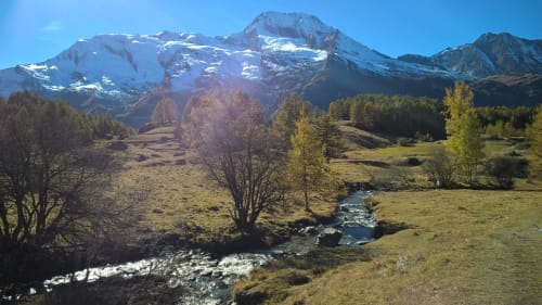 Snow-capped mountain vista with alpine meadow and stream at La Maison De L'Épine, Aime la Plagne