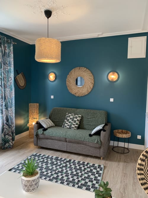 Salon moderne aux tons bleu-vert aux Remparts De Joussaume Latour à Château-Thierry, avec canapé gris et décoration naturelle