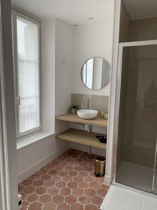 Modern bathroom with circular mirror and white vessel sink at Les Remparts de Joussaume Latour B&B in Château-Thierry