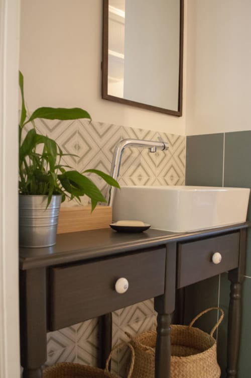 Modern bathroom vanity at Chalet Domisiladoré with vessel sink, dark wood cabinet, geometric backtile, and green plant décor