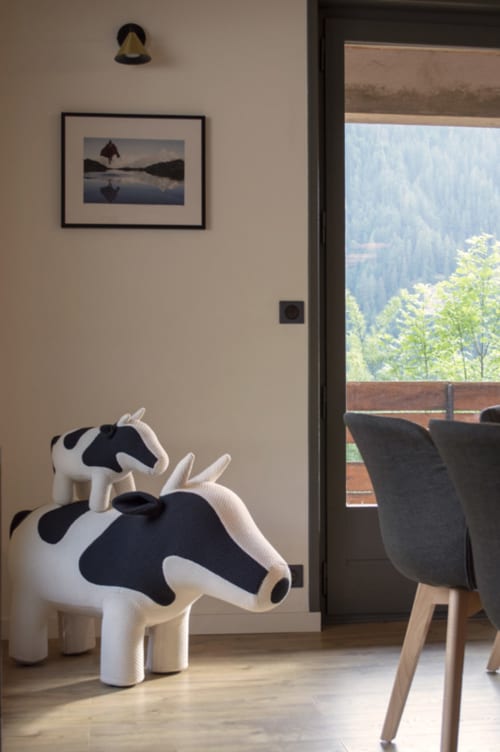 Modern chalet interior with cow-shaped furniture and framed artwork overlooking Alpine mountains at Chalet Domisiladoré,