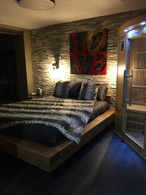 Chambre moderne au Love And Spa à Meynes avec mur en pierre, œuvre LOVE rouge et mobilier contemporain