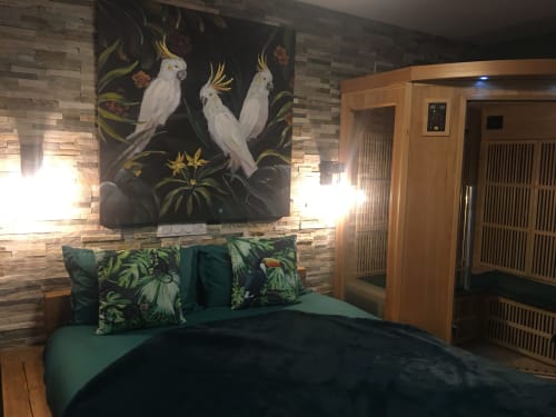 Chambre du Love And Spa avec fresque tropicale, literie verte et porte sauna en bois à Meynes