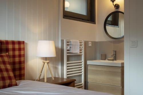 Modern bedroom with en-suite bathroom at Chalet Domisiladoré, featuring contemporary furnishings and mountain view access in