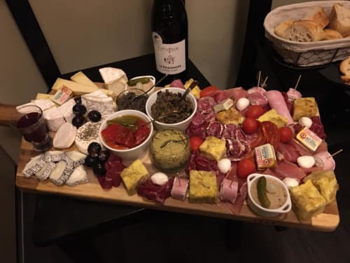 Élégante planche de charcuterie au Love And Spa à Meynes, France, avec charcuteries, fromages, olives et vin.