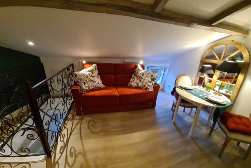 Studio cosy au Petit Nid d'Aigle à Giverny : canapé rouge, coin repas et mobilier élégant