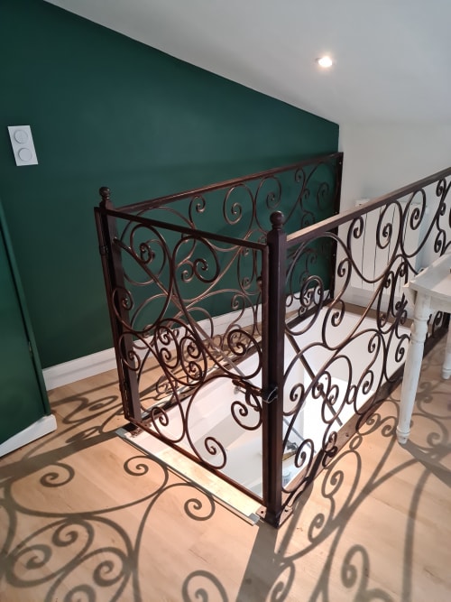 Rampe d'escalier en fer forgé orné au gîte Le Petit Nid d'Aigle à Giverny avec mur d'accent bleu-vert