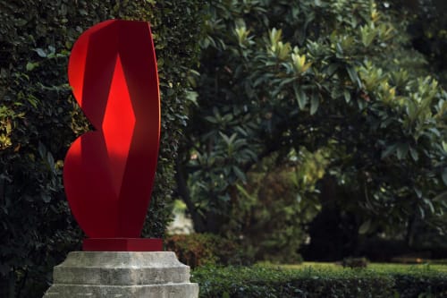 Sculpture abstraite rouge exposée dans le jardin luxuriant de l'hôtel-boutique Mas De Lafeuillade à Montpellier, France
