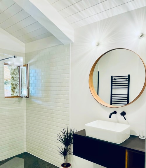 Salle de bain moderne à la Maison Monsieur Léger avec miroir rond, lavabo blanc et carrelage métro à Montaut