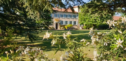 Château de Grandmont, gîte à Blacé avec lys blancs en fleurs dans des jardins entretenus et majestueux manoir historique