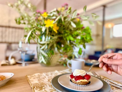 Élégante présentation de dessert à la villa Maison Monsieur Léger à Montaut, avec fruits rouges frais et crème fouettée sur assiette blanche
