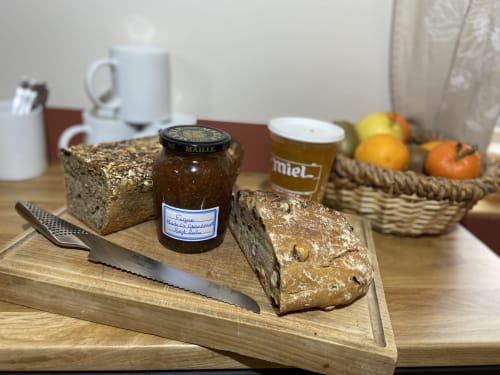 Petit-déjeuner au Château de Grandmont : pain aux graines, confiture, miel et agrumes frais dans un cadre rustique français
