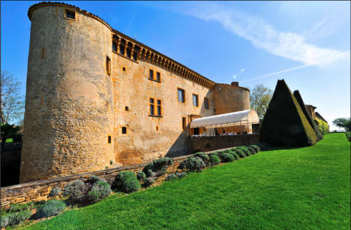 Château de Grandmont, gîte en Blacé : tour en pierre, jardins soignés et cour ensoleillée