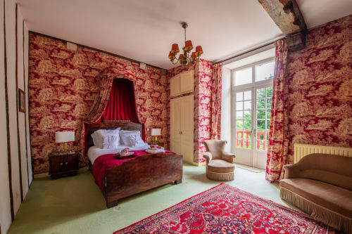 Chambre avec vue sur balcon et lit à baldaquin