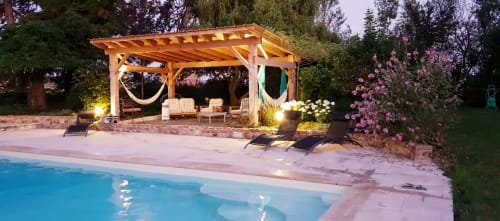 Soirée à la piscine du Château de Grandmont avec pergola illuminée, transats et fleurs en bloom à Blacé, France