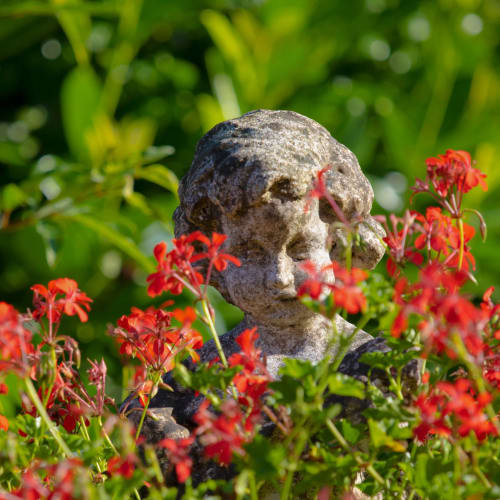 Statue au milieu des géraniums sur la fontaine