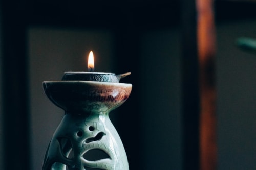 Decorative candle holder with burning flame at Maison Monsieur Léger, Montaut