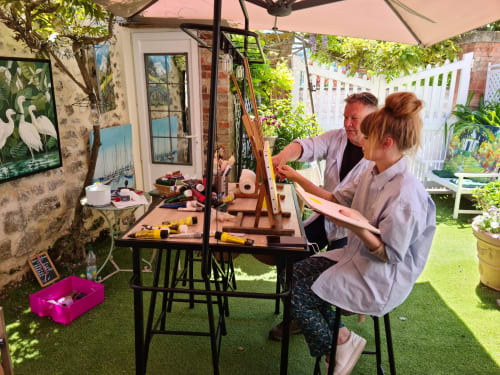 Deux personnes pratiquant le tissage à l'atelier-jardin du Petit Nid d'Aigle à Giverny, France.