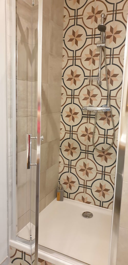 Douche moderne du Château de Grandmont avec carrelage géométrique et pomme de douche pluie à Blacé, France