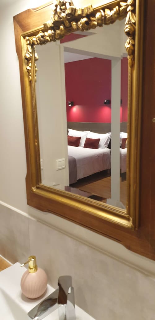 Miroir doré orné reflétant la chambre avec mur d'accent rouge au Château de Grandmont, Blacé