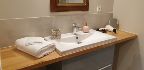 Salle de bains Château de Grandmont Energie avec vasque, serviettes et articles de toilette
