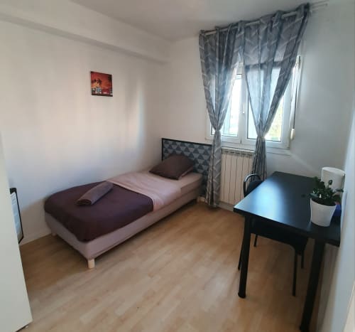 Chambre confortable à NancyRoom B&B à Vandoeuvre-les-Nancy avec lit simple, bureau et vue sur la ville