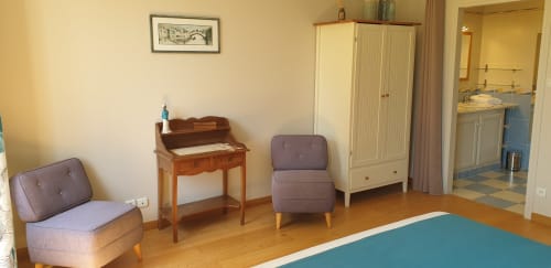 Chambre douillette du Château de Grandmont avec coin salon, bureau en bois, penderie et parquet