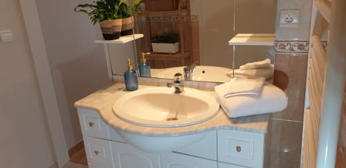 Salle de bain moderne avec vasque ronde, miroir et accessoires à la Château de Grandmont à Blacé